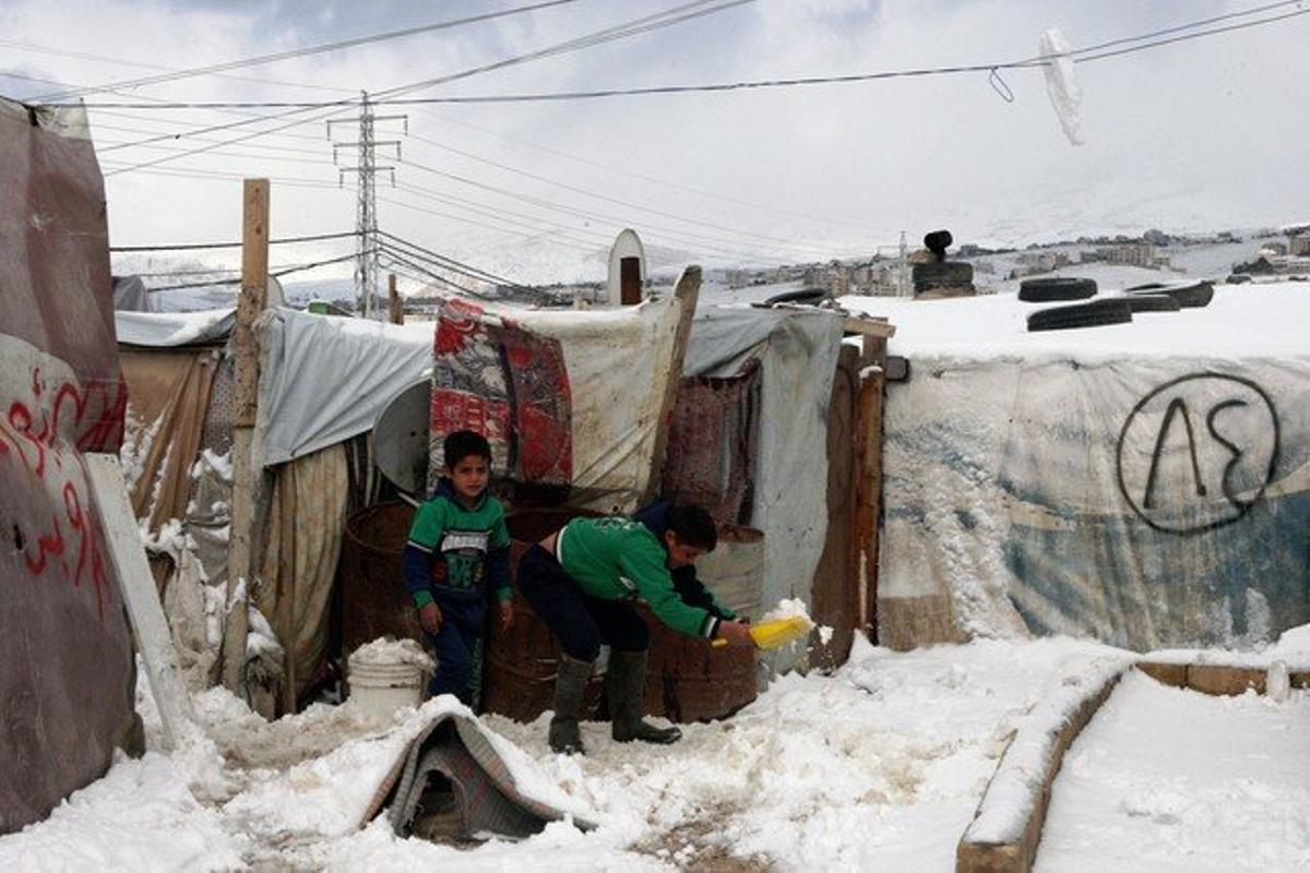 XNM03  Barelias Beekaa Valley  Lebanon   02 01 2016 - A Syrian refugee child removes snow in front his makeshift shelter in the Barelias refugee camp in the Bekaa valley  eastern Lebanon  02 January 2016  According to local reports ongoing snowstorms over the last two days have led to mountain roads in the Bekaa Valley to be closed   Libano  EFE EPA LUCIE PARSAGHIAN