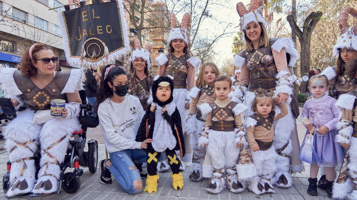 Una de las comparsas cacereñas posa junto al pequeño Luis y su madre, ayer en Cánovas.