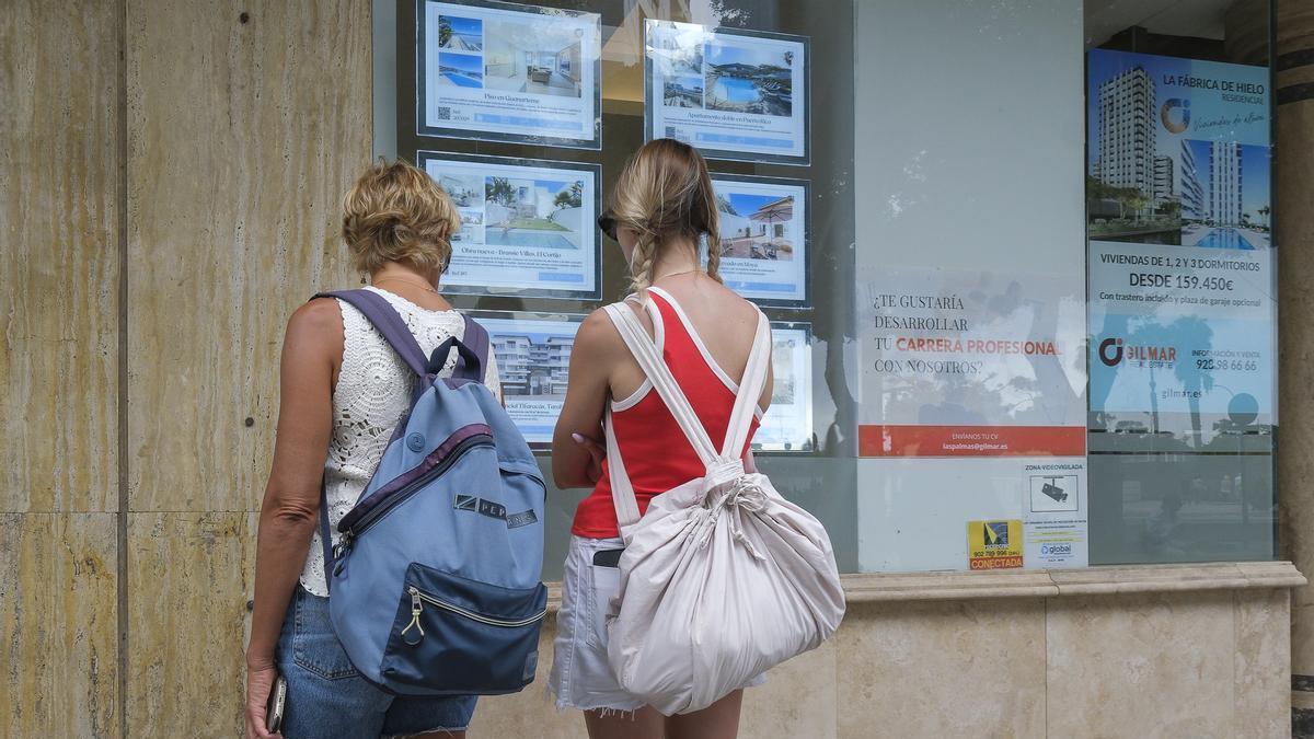 Dos mujeres observan las ofertas de una inmobiliaria de las Islas.