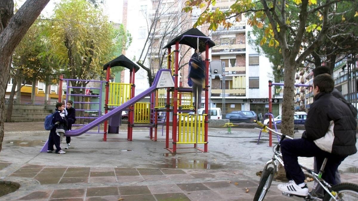 Unos niños juegan en un parque con toboganes.