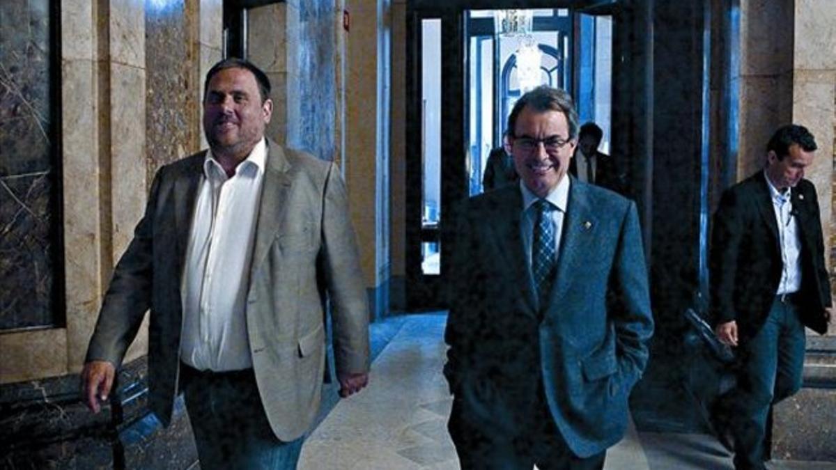 El líder de ERC, Oriol Junqueras, y el presidente de la Generalitat, Artur Mas, ayer en los pasillos del Parlament.