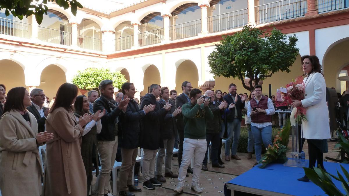 Matilde Esteo, en el escenario, recibe el aplauso de sus compañeros de partido.