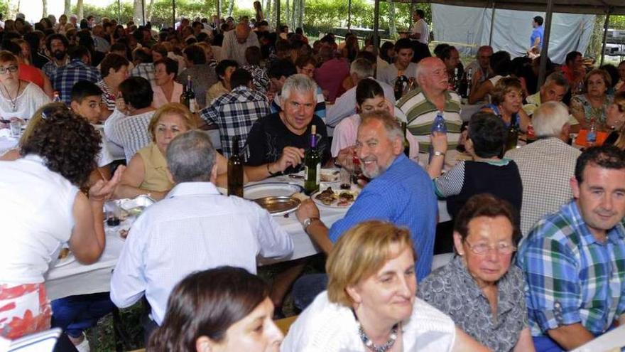 Arriba, asistentes a la comida campestre que tuvo lugar en la carballeira. A la derecha, niños en los hinchables.