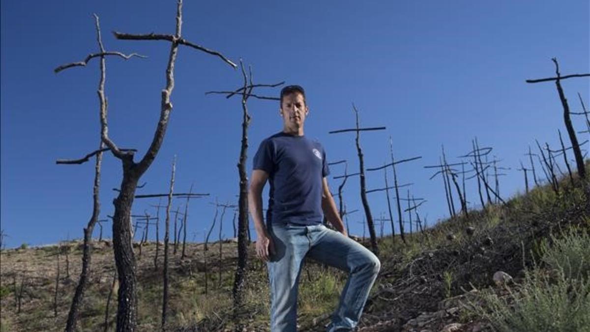 El bombero y artista Marc Sellarès en el bosque de cruces que ha creado en la zona del incendio de Ódena.