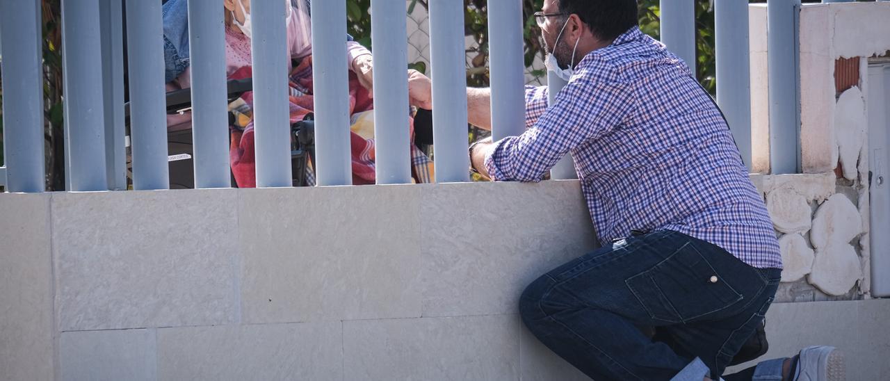Un familiar de una usuaria se comunica a través de la valla de la residencia durante la pandemia