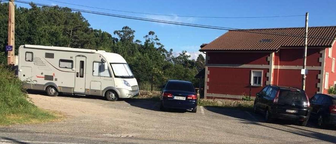 Una persona toma el sol en una silla junto a su autocaravana. // S.Á.