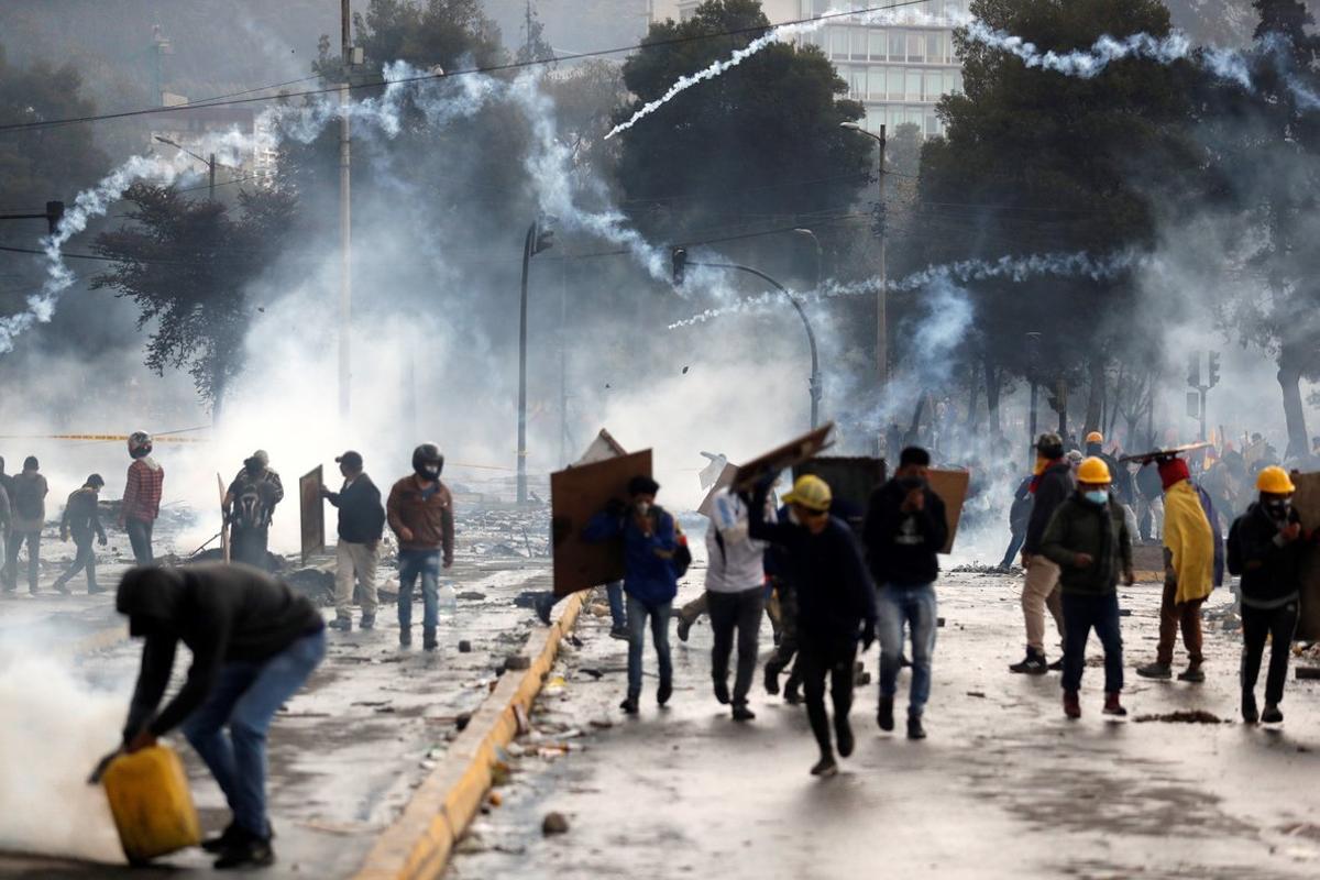 AME9172. QUITO (ECUADOR), 13/10/2019.- Manifestantes corren entre los gases lacrimógenos lanzados por la policía en una nueva jornada de choques este domingo, en Quito (Ecuador). Las protestas comenzaron el 3 de octubre contra las medidas de austeridad económicas adoptadas por el Gobierno, especialmente la eliminación de los subsidios a los combustibles, como parte de las condiciones puestas por el Fondo Monetario Internacional (FMI) y otras instituciones para un crédito de 10.000 millones de dólares. EFE/ Paolo Aguilar