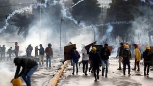 AME9172. QUITO (ECUADOR), 13/10/2019.- Manifestantes corren entre los gases lacrimógenos lanzados por la policía en una nueva jornada de choques este domingo, en Quito (Ecuador). Las protestas comenzaron el 3 de octubre contra las medidas de austeridad económicas adoptadas por el Gobierno, especialmente la eliminación de los subsidios a los combustibles, como parte de las condiciones puestas por el Fondo Monetario Internacional (FMI) y otras instituciones para un crédito de 10.000 millones de dólares. EFE/ Paolo Aguilar