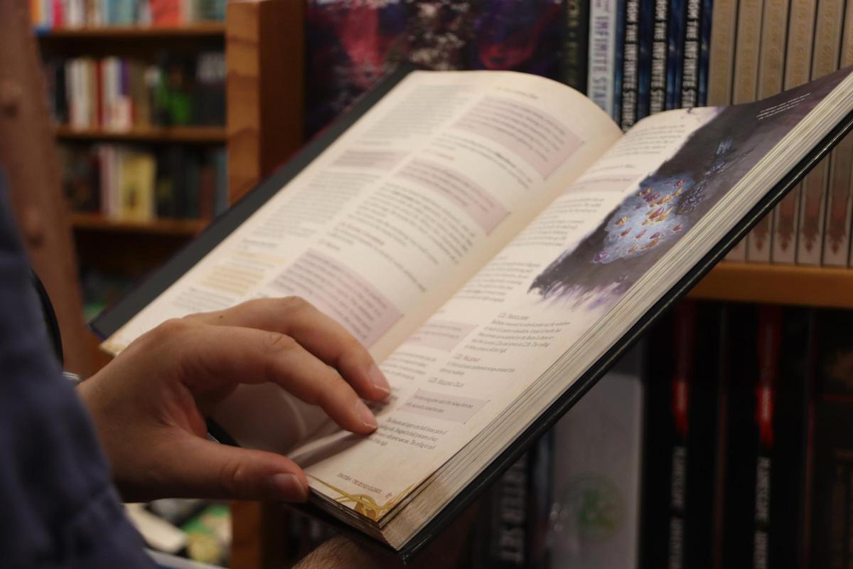 Un home fulleja un llibre en una llibreria de Barcelona