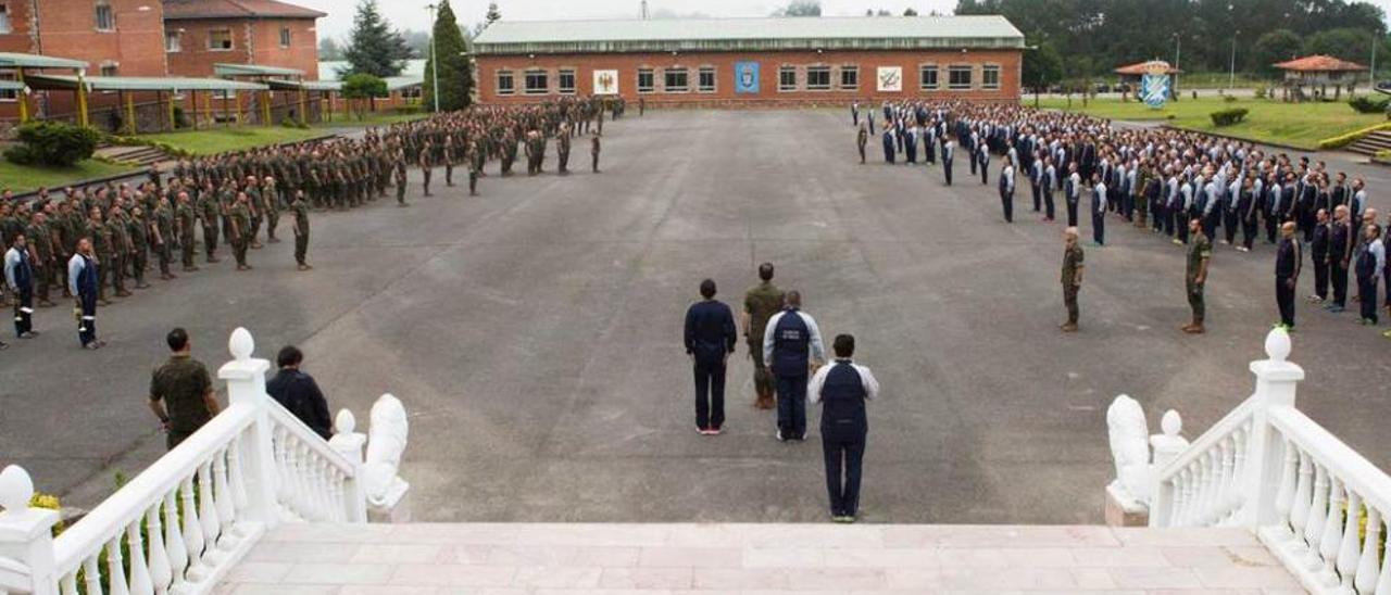 Acto de izada de bandera en el acuartelamiento Cabo Noval de La Belga (Siero), con uno de los batallones, a la derecha, preparado para realizar una actividad de entrenamiento físico.