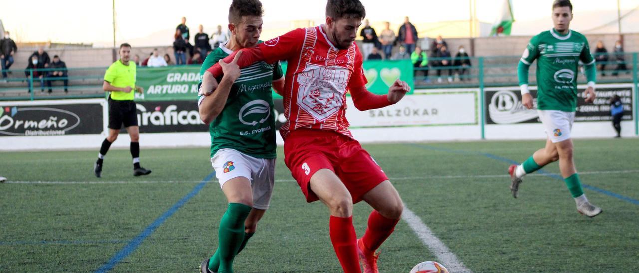 Ismael protege el balón ante David López en el Moralo-Arroyo de la primera vuelta.