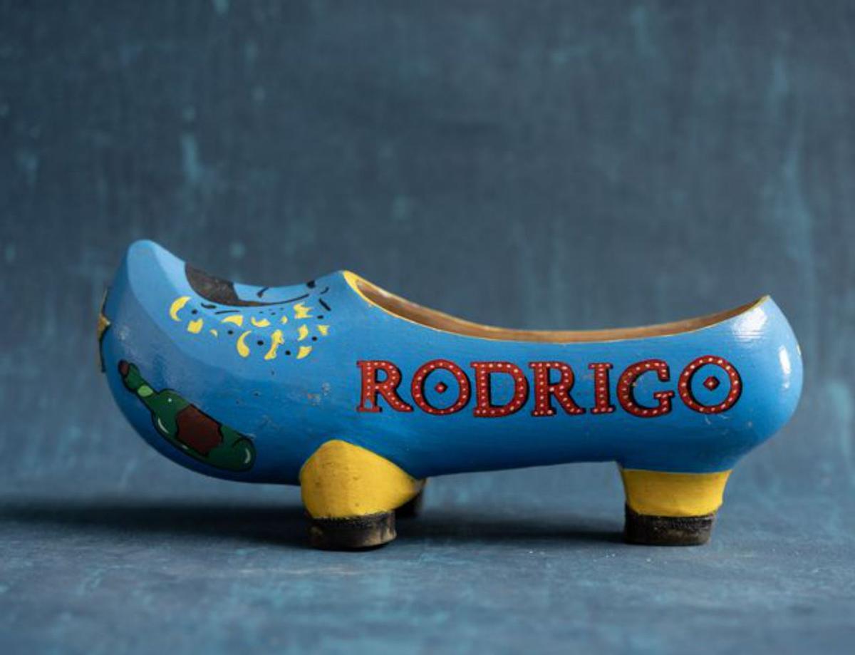 Rodrigo Cuevas, retratado por Manu Mendi y Bernardo Baragaño y, bajo estas líneas, algunos de los objetos que se mostrarán en la exposición: una polaroid del artista, una vieja bota de vino y una madreña decorada,  con su nombre.