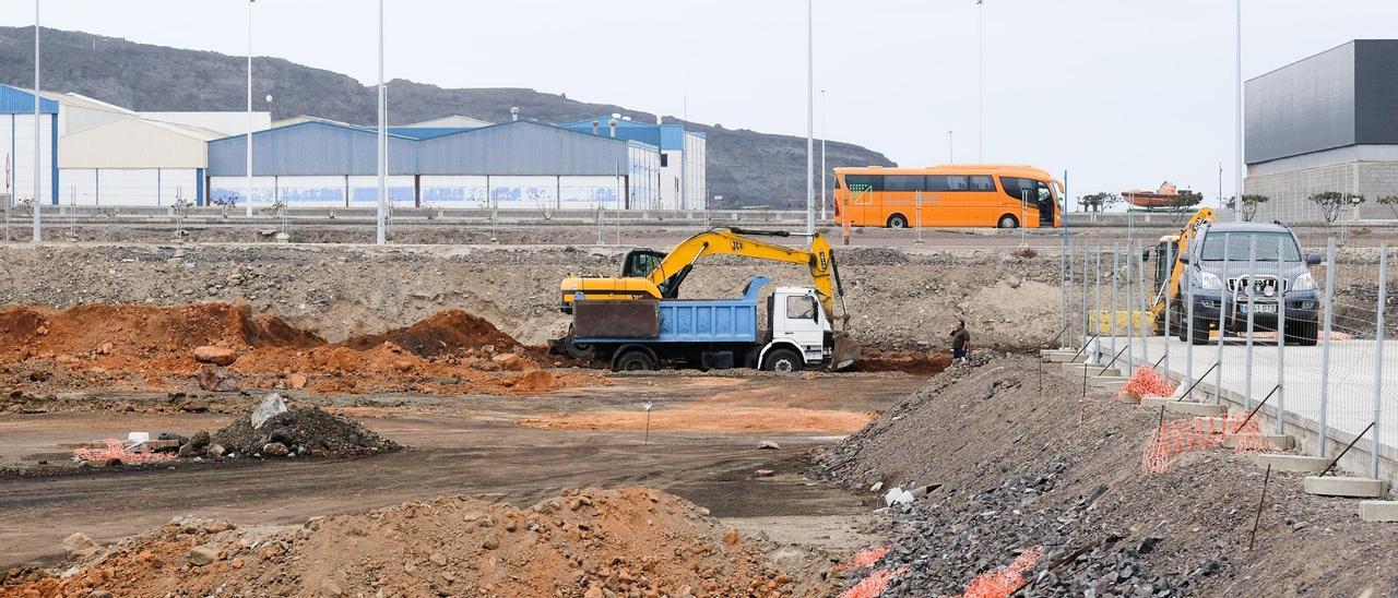 Una retroexcavadora y un camión trabajan en la parcela de la terminal de vehículos del Puerto.