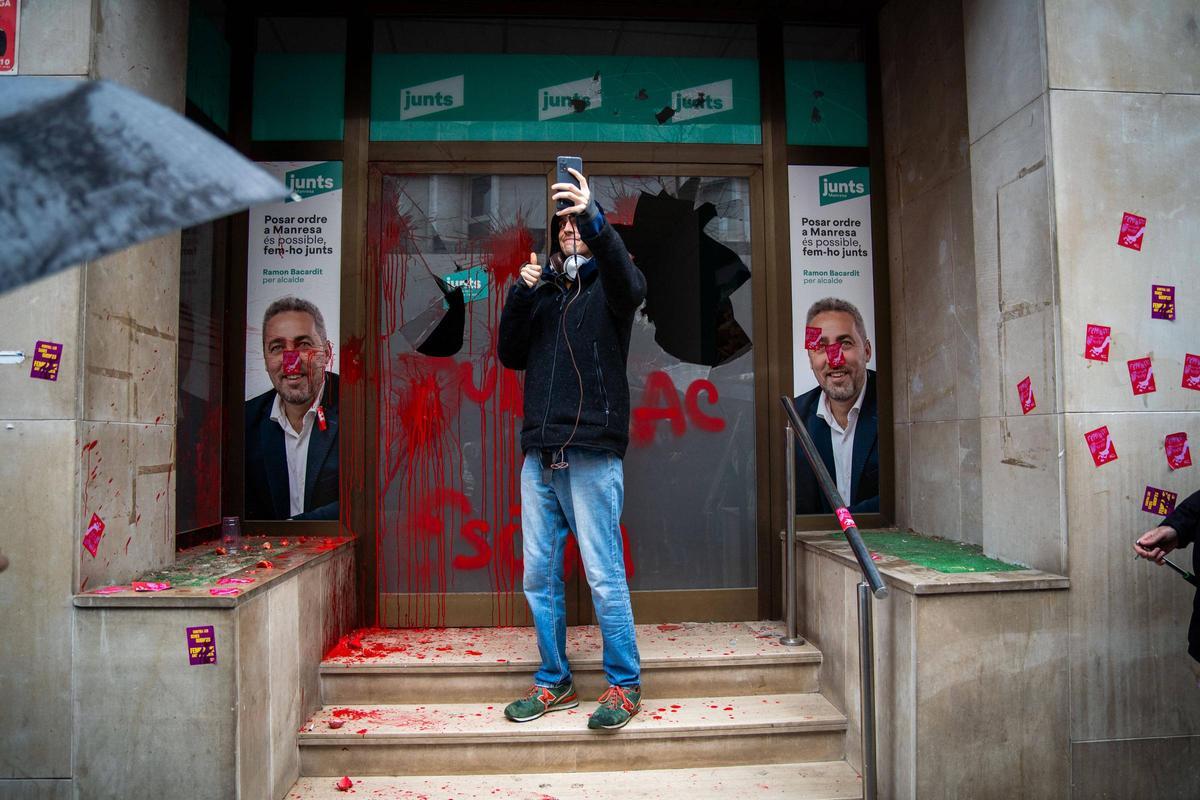 Una persona es retrata davant la seu de Junts un cop fetes les destroises