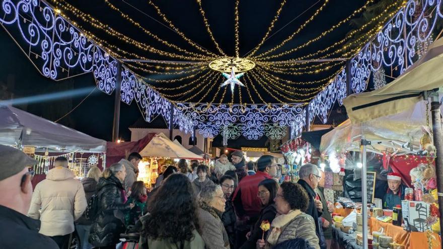 Visitantes en los puestos del mercado navideño.