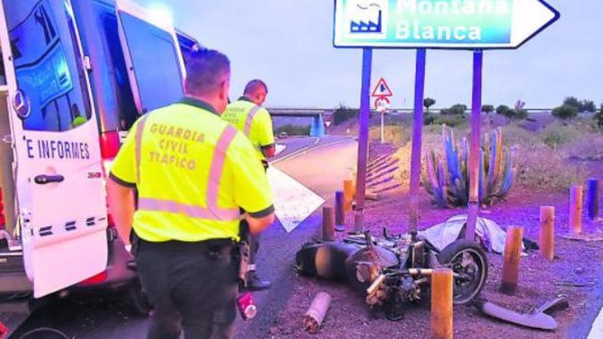 Una pareja de la Guardia Civil, ayer, realizando el atestado junto al cuerpo del fallecido y su moto.