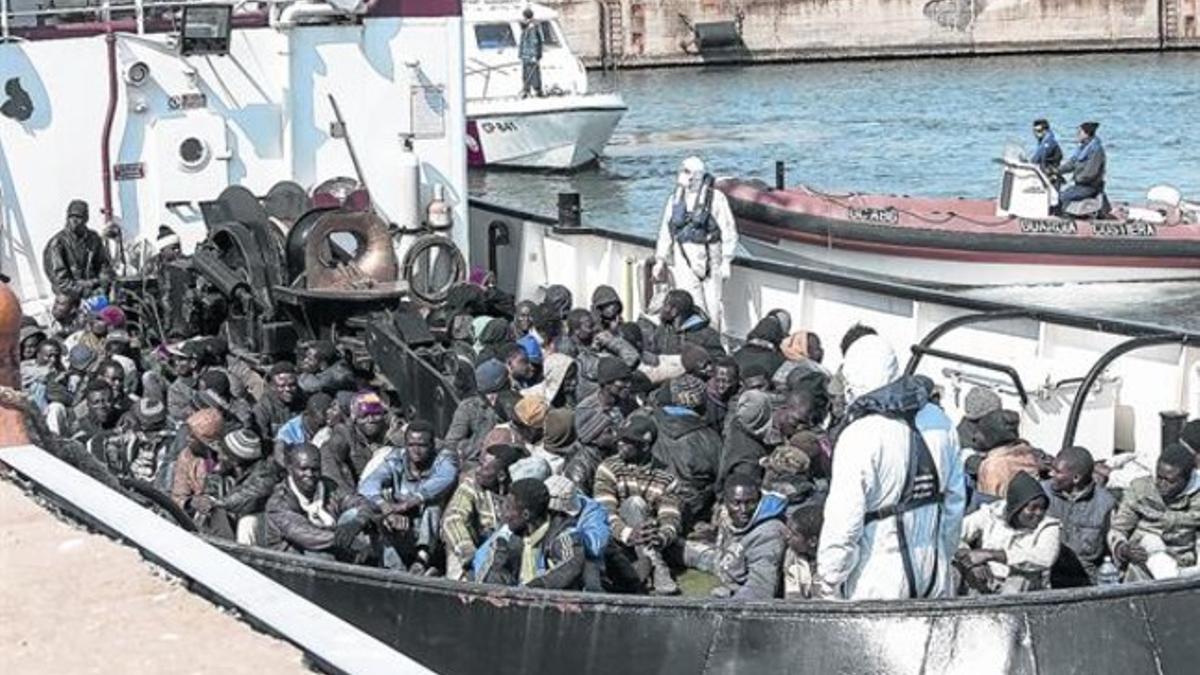 Un grupo de inmigrantes rescatados por la embarcación RBD llega al puerto de Corigliano Calabro, este miércoles.