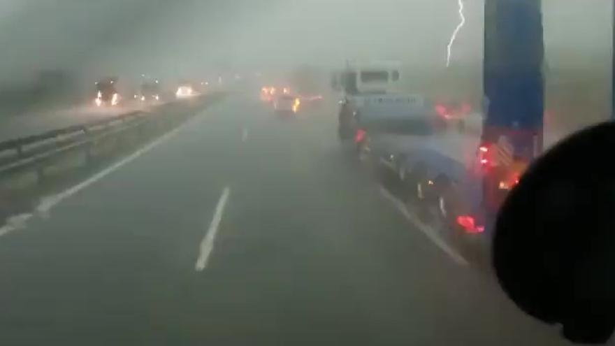 Un rayo impacta junto a los coches parados en una carretera en Xàtiva