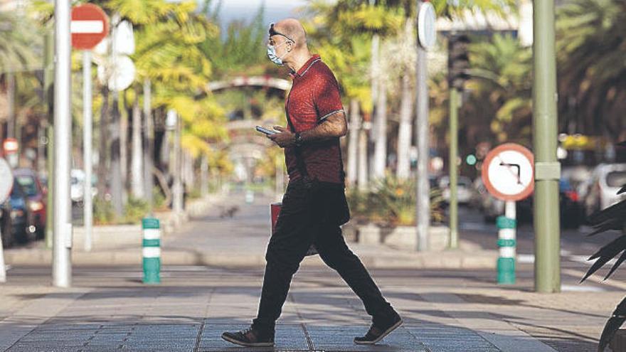 Un hombre camina con mascarilla por la avenida Tres de Mayo de Santa Cruz de Tenerife.