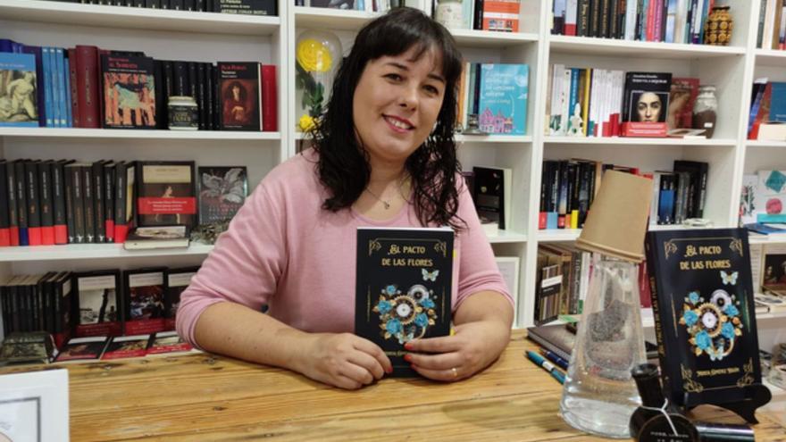 La escritora Mireia Giménez, con su libro “El Pacto de las Flores”, tras la presentación en Benavente. | E. P.
