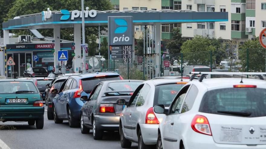 Varios coches hacen cola en una gasolinera.