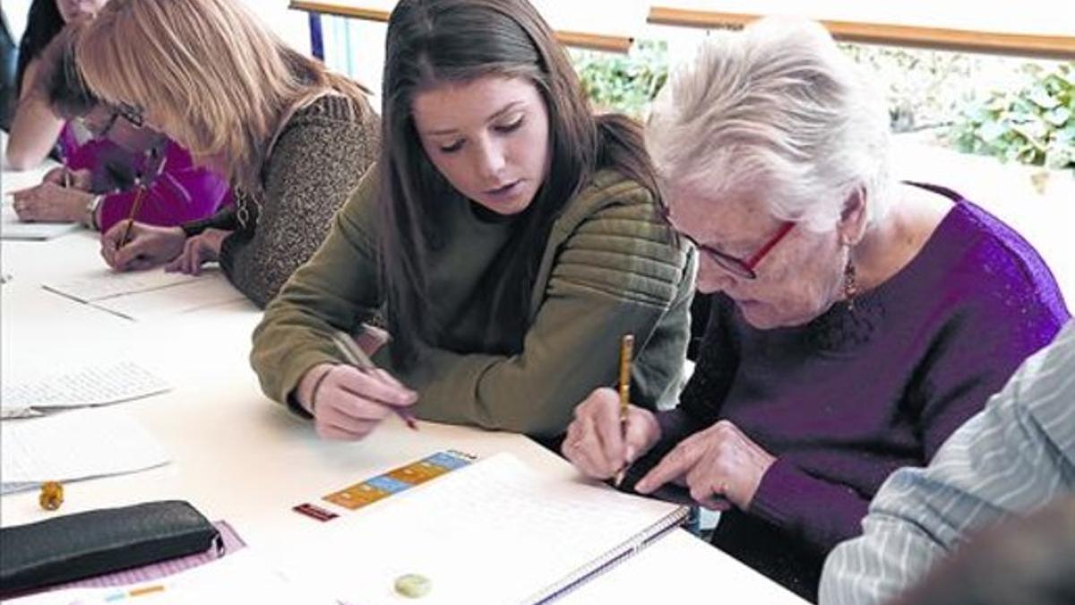 Ayuda intergeneracional 8Una voluntaria ayuda a María Gloria Latorre con los ejercicios de ortografía.