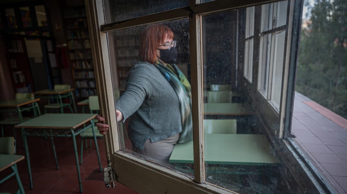 La directora del instituto Lluís Vives de Barcelona, Núria Prunés, abre una ventana para ventilar un aula.