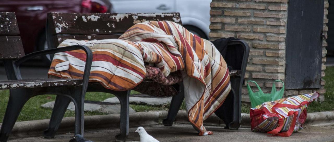 Un sintecho duerme en un banco de Alicante, en una imagen de archivo