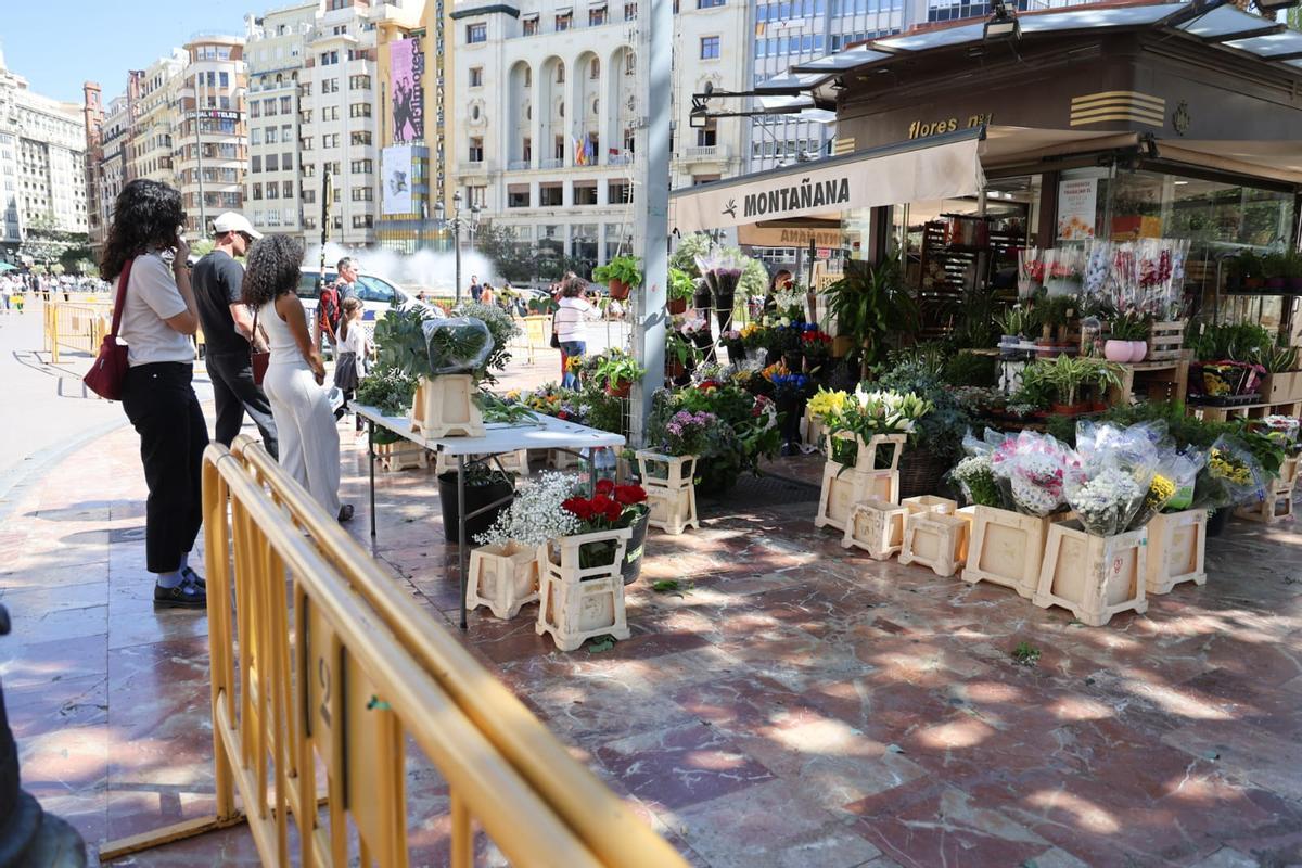 Vallas rodean un puesto de flores de la plaza del Ayuntamiento por el disparo de la mascletà aplazada en Fallas.
