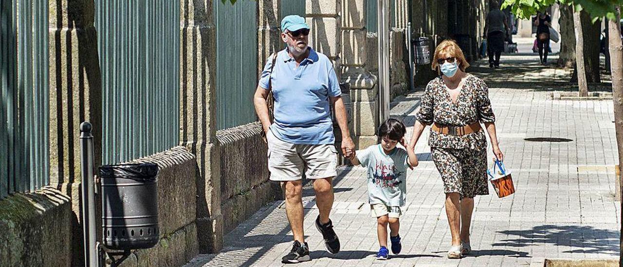 Dos adultos y un niño paseando ayer por el entorno del jardín del Posío.