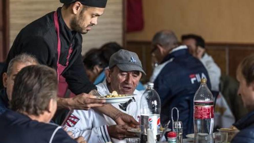 Un voluntario, atendiendo las mesas en el comedor social Prosperidad de San Gabriel, ayer.