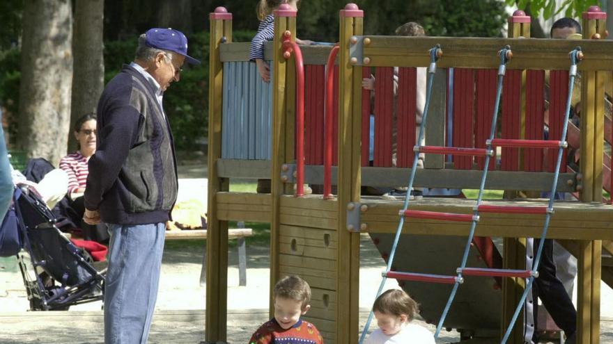 Unos niños juegan en un parque de Madrid bajo la atenta mirada de un abuelo.
