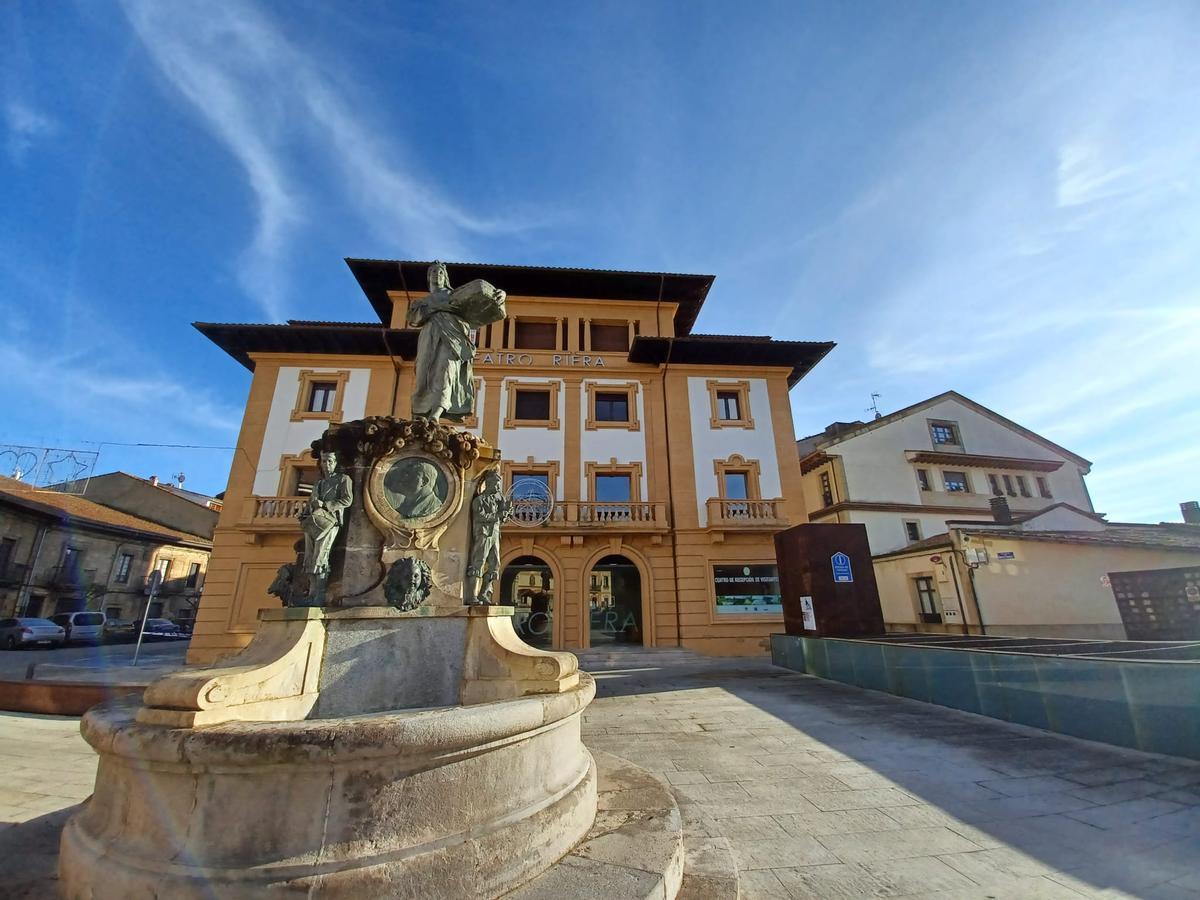 La escultura de La Manzanera, con el Teatro Riera de Villaviciosa al fondo.