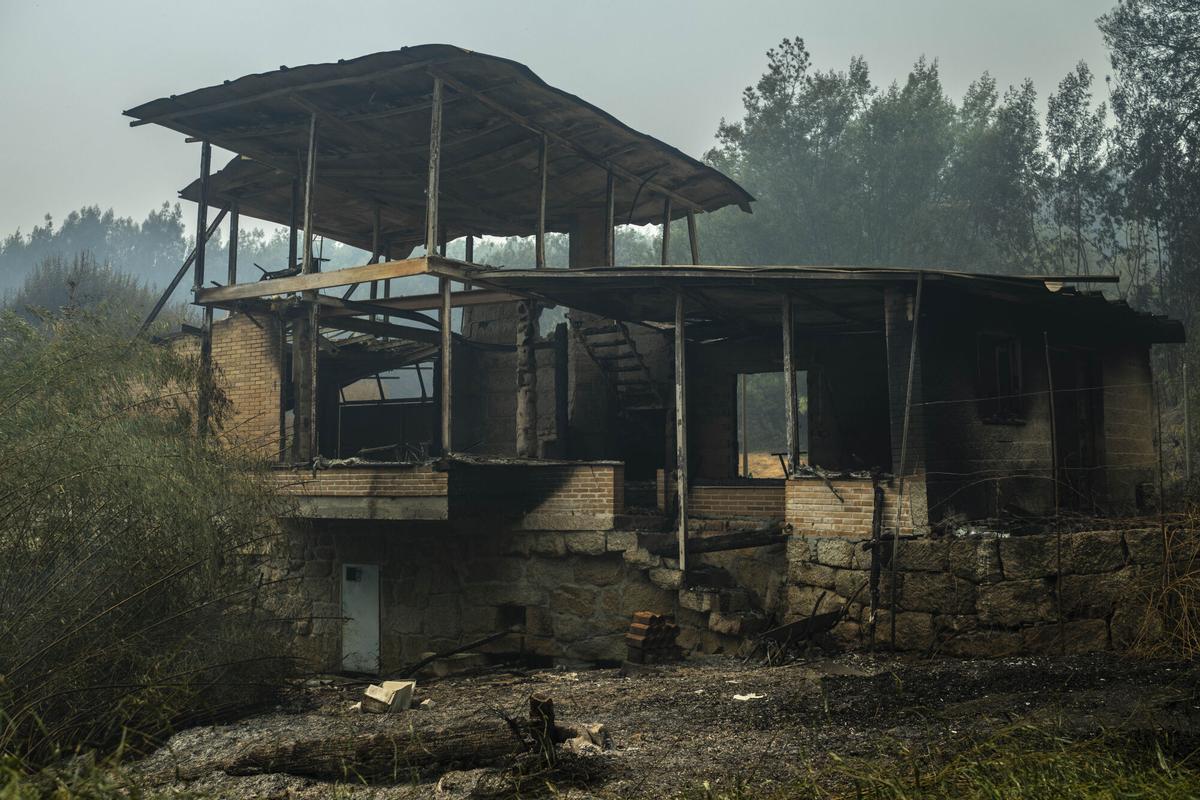 Vista de una construcción calcinada como consecuencia del incendio forestal en Carballeda de Avia (Ourense), este sábado