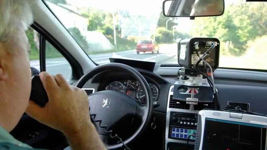 Un agente en un control de velocidad con radar móvil en una carretera de A Coruña.