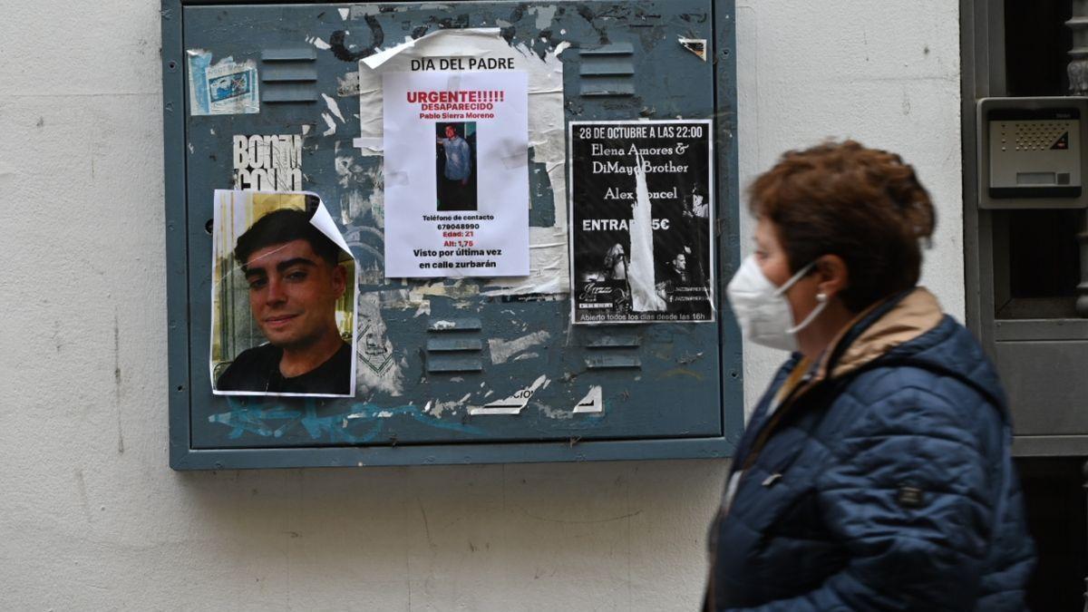 Una mujer pasa delante de dos carteles que informan sobre la desaparición de Pablo Sierra.