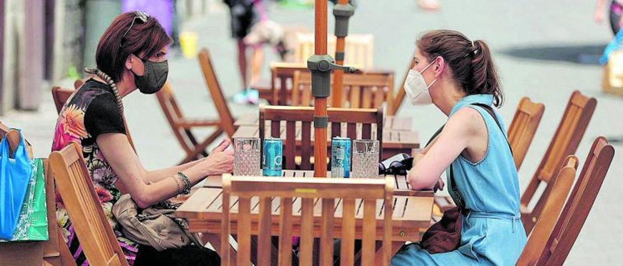 Dos turistas toman un refrigerio en una terraza.