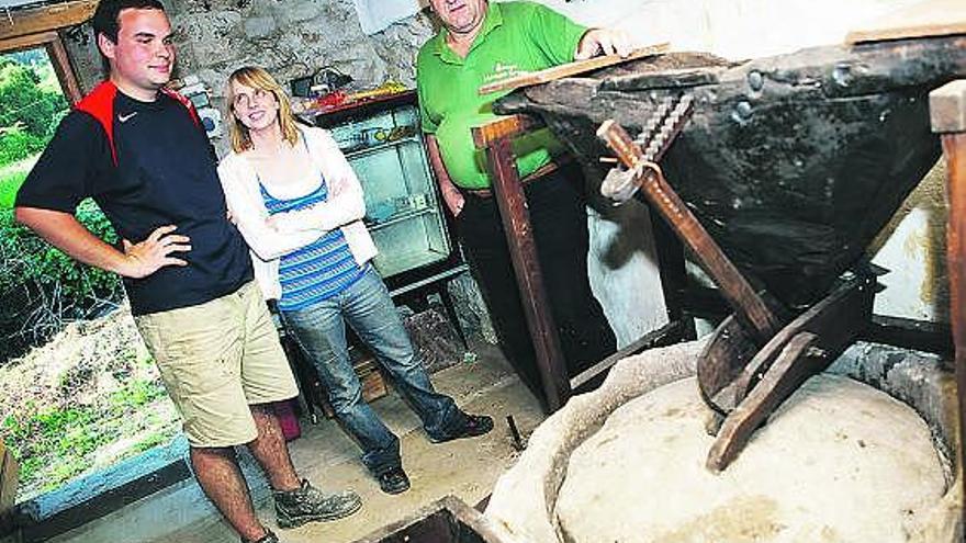 Virgilio Martínez, a la derecha, junto a su sobrino Ignacio y la novia de éste, Olaia Pérez, en el interior del molino.