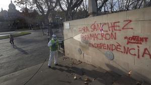 Operarios de limpieza eliminan pintadas en contra de la cumbre hispano-francesa en Barcelona