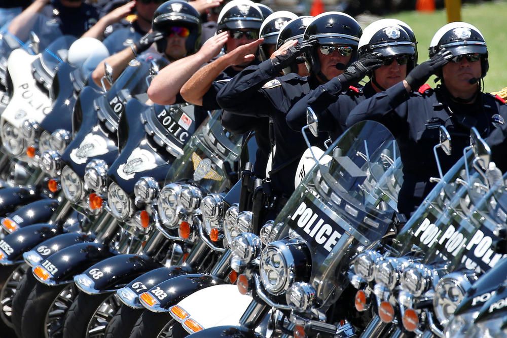 Oficiales de policía saludan durante el funeral del fallecido sargento Michael Smith en Dallas, Texas.