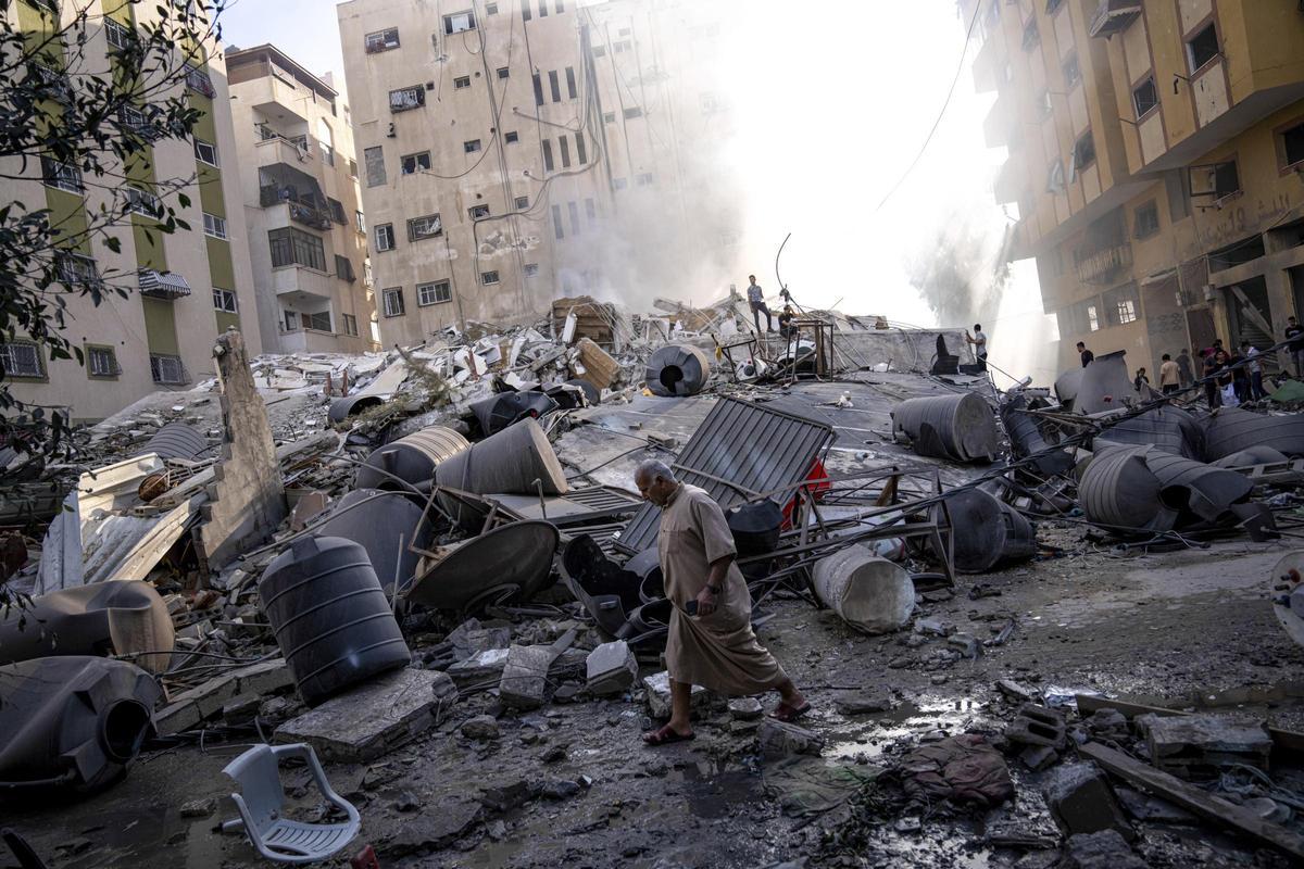 Palestinos inspeccionan los escombros de un edificio después de que fuera alcanzado por un ataque aéreo israelí en la ciudad de Gaza.