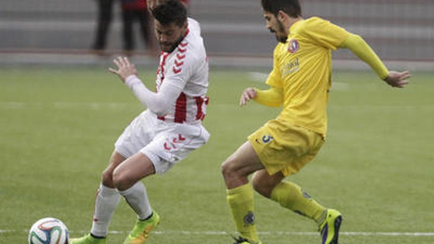 David Agudo (Huracán) controla la pilota davant la pressió de Rubén Canelada, defensa de l&#039;Olot.