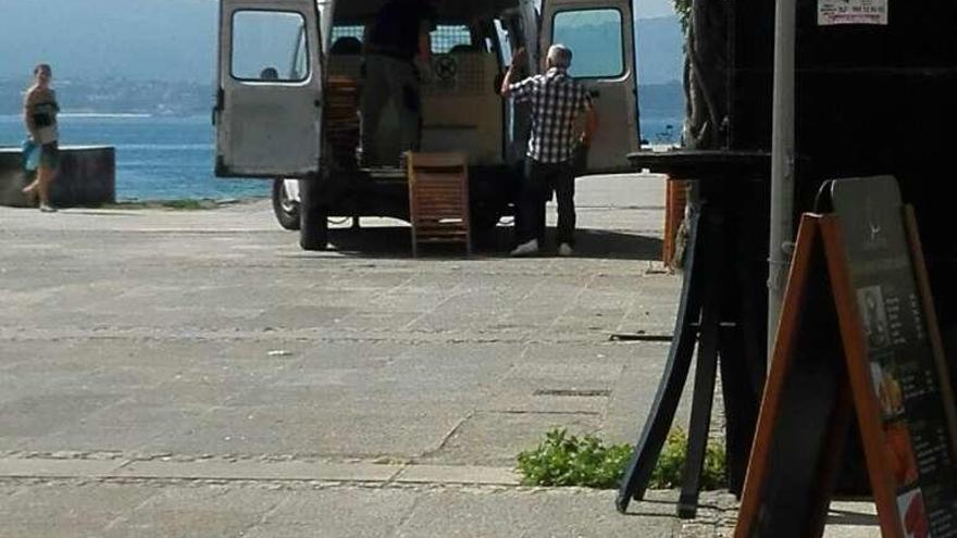 Trabajadores municipales colocando sillas para el mitin de En Marea en la Praza das Pontes de Cangas. //