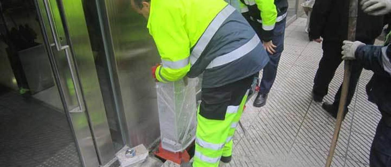 Operarios instalando ayer los parquímetros de la zona azul en la avenida de Galicia.