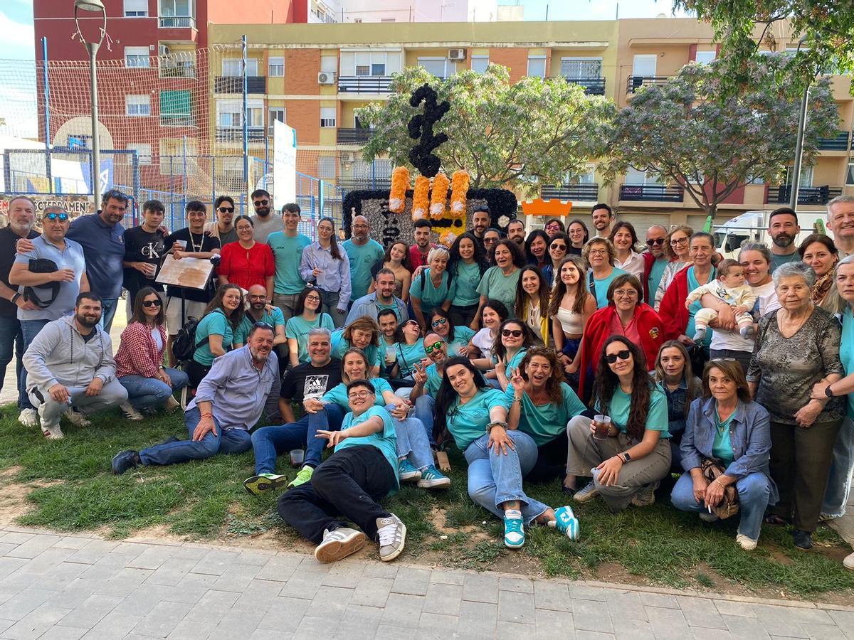 Falleros y falleras con la cruz de mayo que representa las 228 muertes en lo alto de ella.