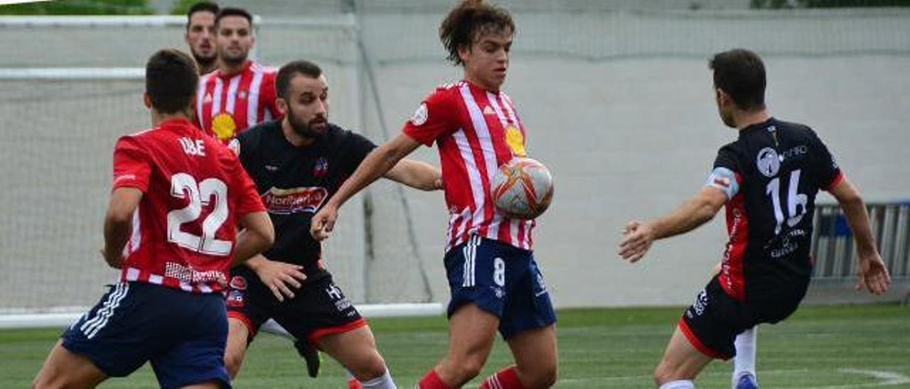 Cacheda trata de controlar el balón ante dos futbolistas del Estradense. |  // GONZALO NÚÑEZ