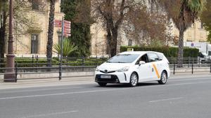 Un taxi circula por una calle de Sevilla.
