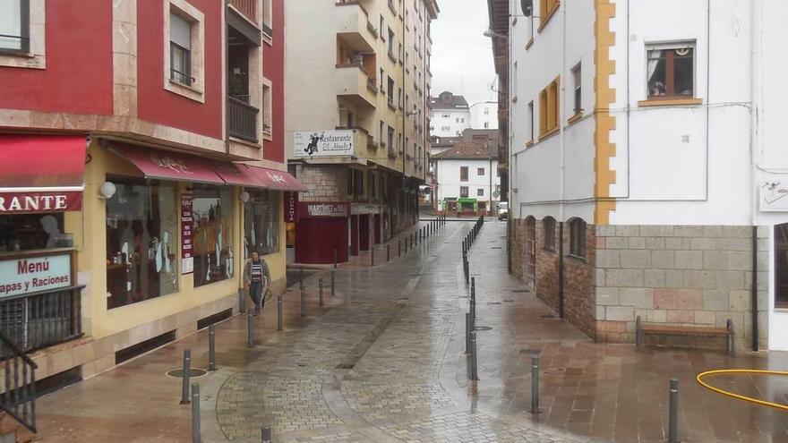 Un peatón avanza por la travesía de El Fondón, en Cangas de Onís.