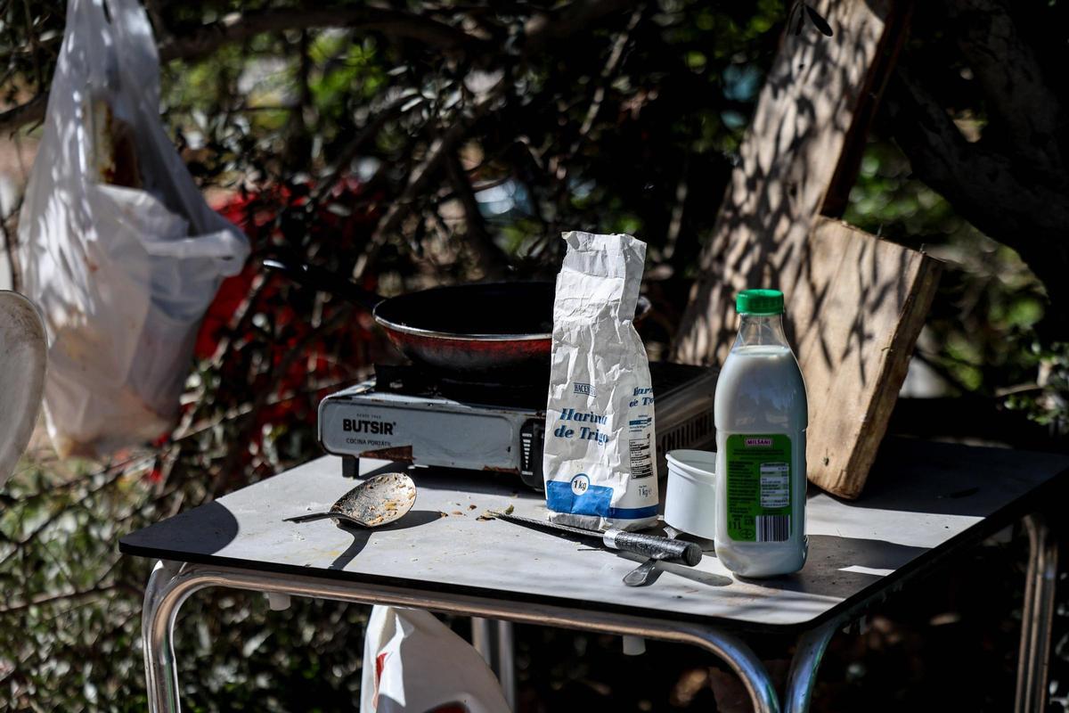 Una botella de leche y una bolsa de harina sobre la mesa, en un asentamiento de infraviviendas en Ibiza.