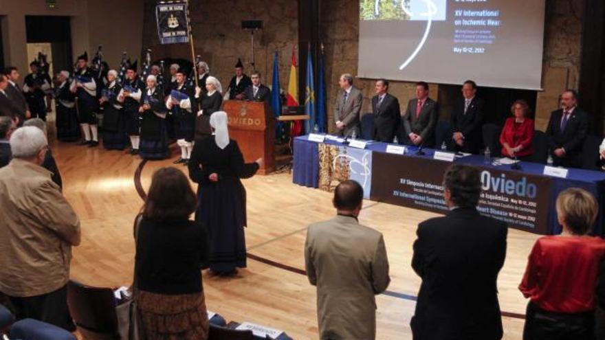 Congresistas e invitados, en pie para escuchar el himno de Asturias durante la inauguración.